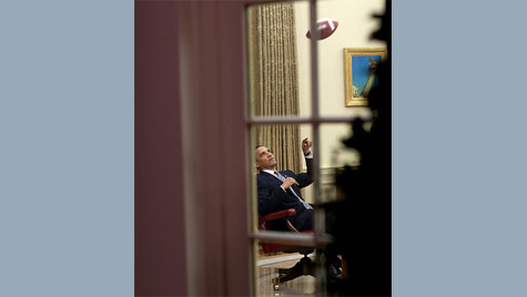 Obama playing with football at his desk in Oval Office