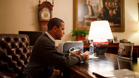 Obama reading letter in a sweater 