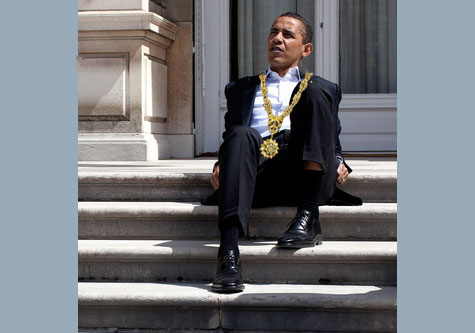 A tired President Obama sits down on cement steps 